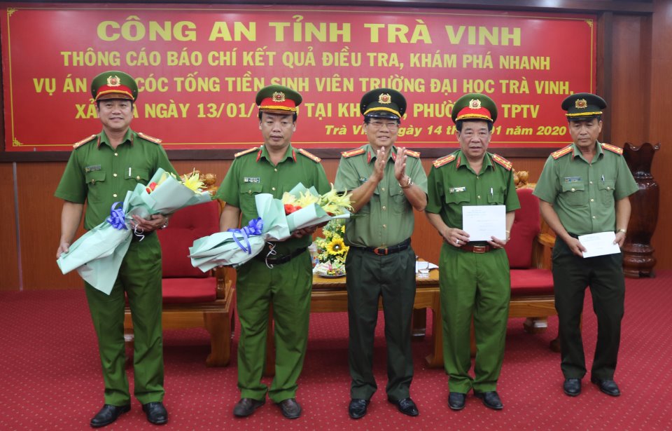 Đại tá Lê Văn Việt, Giám đốc Công an tỉnh thừa ủy quyền của Chủ tịch UBND tỉnh trao hoa và tiền thưởng nóng cho đại diện tổ công tác đặc biệt.  Ảnh: HOÀI THƯƠNG